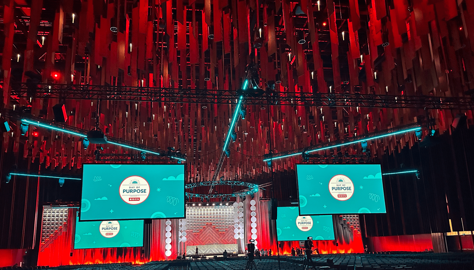 Photo of BECU's Day of Purpose event held in 2023. Image shows many projection screens and overhead lighting and rigging.